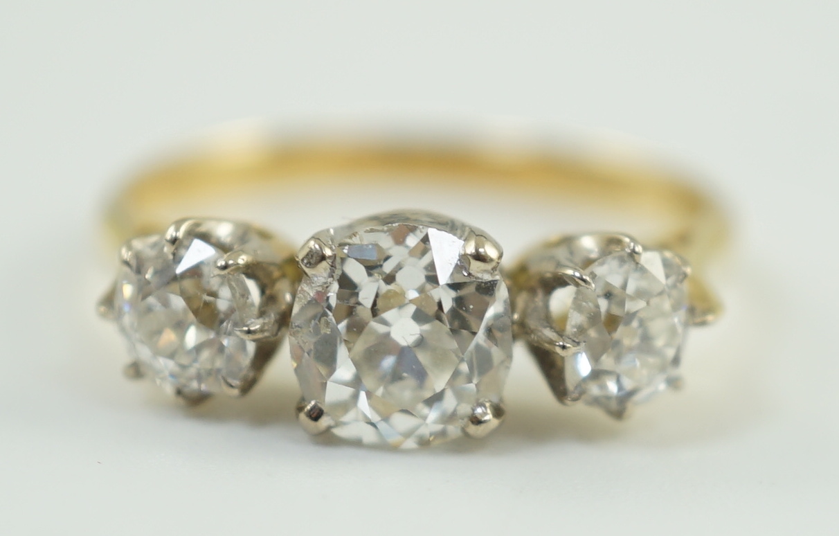 A modern 18ct gold and three stone diamond set ring